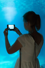 Woman doing photos in the aquarium.