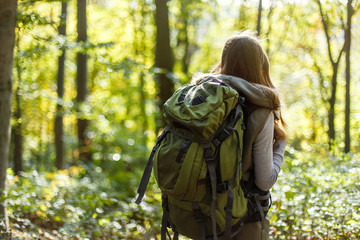 Cheerful brunette tourist girl backpacked have walk through forest, autumn tourism concept