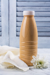 Baked milk in a plastic bottle. Dairy beverage popular in Russia and Ukraine. Rustic style. Copy space