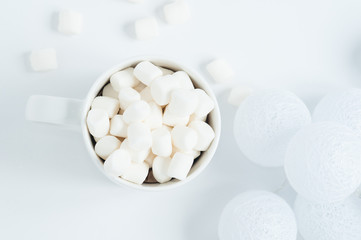 Fototapeta na wymiar white mug with marshmallows in a winter scene