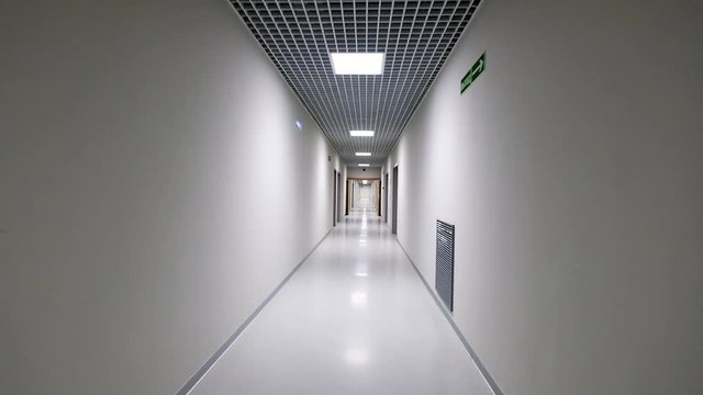 POV walking in a long white empty corridor interior