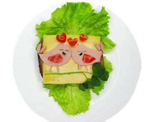 creative food sandwich with sausage and cheese served on lettuce