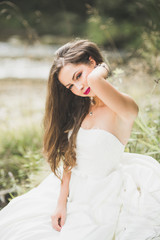 Naklejka premium Portrait of stunning bride with long hair standing by the river