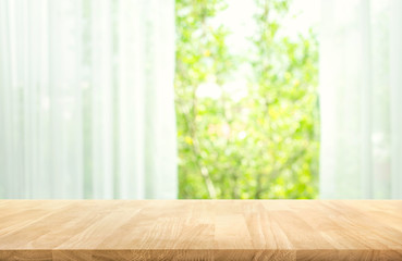 Empty of wood table top on blur of curtain with window view green from tree garden background.For...