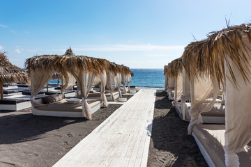 Relaxation zone on the black beach between the villages of Perissa and Perivolos in Santorini