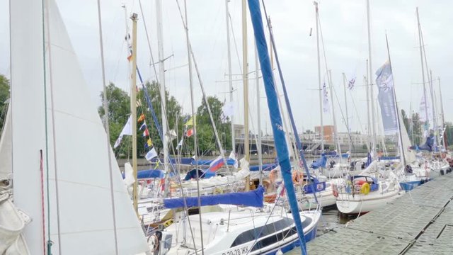 City quay. Sailing regatta. Yacht club, port. A rainy summer day. Yachts are laid up. Safe harbor, calm water. Overcast windy. People walk on the pier. Kaliningrad - July 2017 Russian.