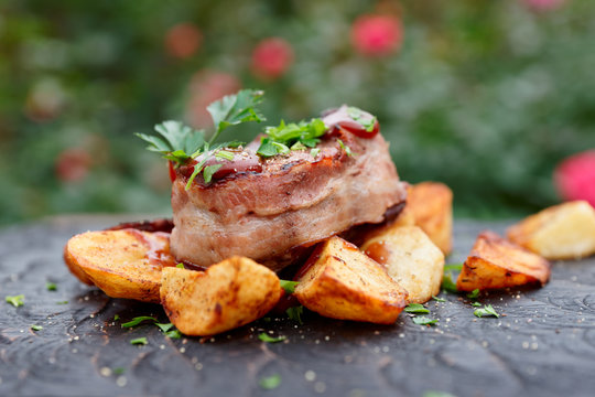 Tenderloin steak and fried potatoes with bbq sauce and chopped parsley