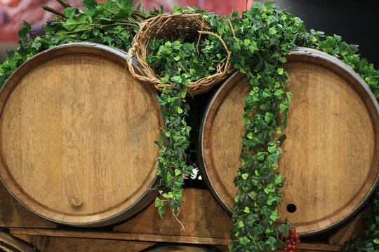 des Tonneaux &agrave; vin en bois pour vignoble d&eacute;cor&eacute;s de feuilles de lierres et de grappes de raisins