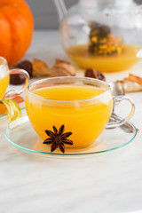 sea buckthorn tea with cinnamon and spices in beautiful glass cup. Natural light, selective focus. 