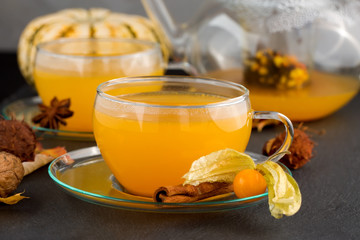 sea buckthorn tea with cinnamon and spices in beautiful glass cup. Natural light, selective focus. 