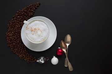 Cappuccino and coffee beans on dark background. Natural light, selective focus. Xmas theme.