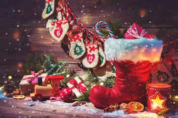 Advent calendar and Santa's shoe with gifts on rustic wooden background