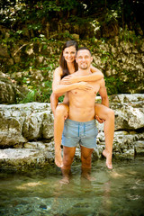 Active young couple chilling out in river  on a hot summer day standing and walking in water