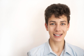 A cute guy smiles at the white background