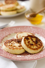 Cottage cheese pancakes, homemade syrniki with honey and sour cream.