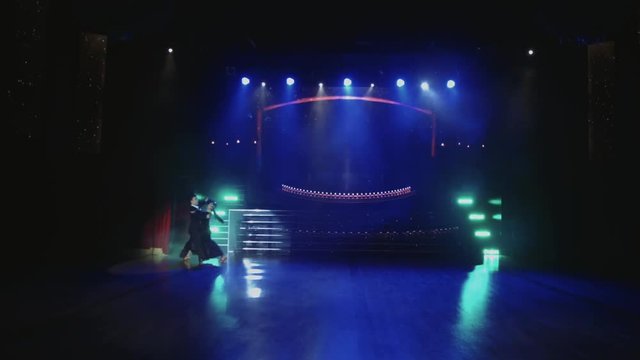 Beautiful young couple dancing tango on stage