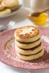 Cottage cheese pancakes, homemade syrniki with honey and sour cream.