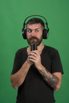 Man holds microphone on green background. Technologies and music concept.