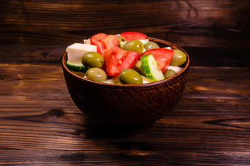 Greek salad in a bowl on wooden table