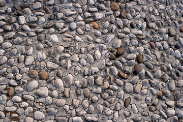 Road from small cobblestone for stone texture or seamless background.