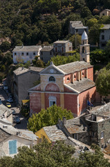 Fototapeta na wymiar Corsica, 28/08/2017: la chiesa rosa di Santa Giulia (XVI secolo) nello skyline di Nonza, uno dei borghi più famosi del Capo Corso
