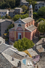 Fototapeta na wymiar Corsica, 28/08/2017: la chiesa rosa di Santa Giulia (XVI secolo) nello skyline di Nonza, uno dei borghi più famosi del Capo Corso