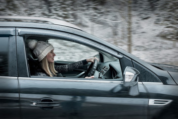 Woman at winter time. Yoyng female sitting and driving in black