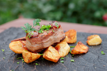 Tenderloin steak and fried potatoes with bbq sauce and parsley, outdoor