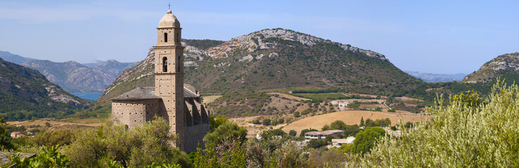 Corsica, 28/08/2017: vista panoramica della chiesa di San Martino (XVI secolo) a Patrimonio, villaggio dell'Alta Corsica circondato da colline verdi e vigneti - obrazy, fototapety, plakaty