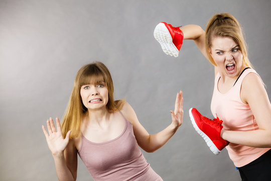 Agressive women fighting using shoes with female