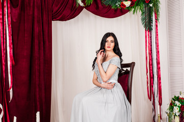 Fototapeta premium young woman in elegant blue gray evening dress indoors with beautiful interior