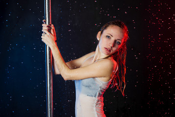 a young beautiful European Ukrainian woman in a photo studio with water is engaged in half-dancing...