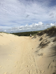 A 50 year old woman with a backpack walks over the dunes at Shackleford Banks, North Carolina. Model Release on file-Joyce Green  iphone