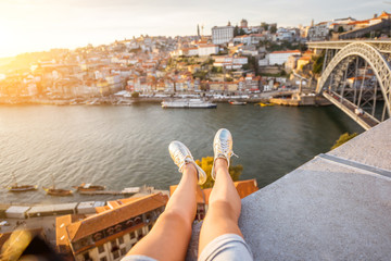 Female legs on the beautiful landscape view background during the sunset in Porto city, Portugal