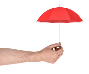 A large male arm holds a tiny red open umbrella isolated on a white background.
