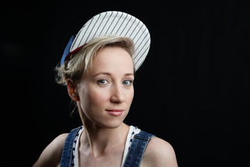woman in a baseball cap smiling on a black background