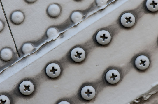 CLOSE-UP OF RIVETS AND SCREWS ON A MILITARY HELICOPTER.