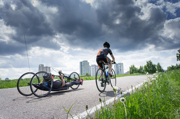 two biker by race cycling contest. one sporsmen is on the recumbent bicycle, other one is on the...