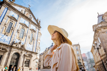 Young woman tourist standing near the Congregados church with famous portuguese blue tiles on the facade traveling in Porto city. Portugal - obrazy, fototapety, plakaty