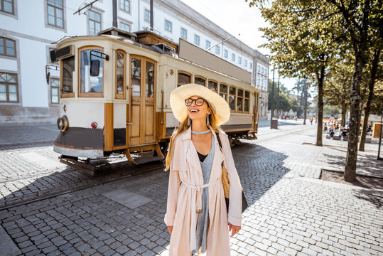 Lifestyle portrait of a woman near the famous old touristic tram on the street in Porto city, Portugal