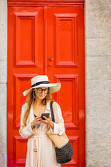 Young woman tourist on the red retro style door background