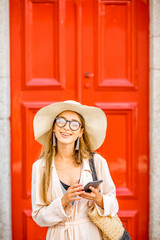 Young woman tourist on the red retro style door background