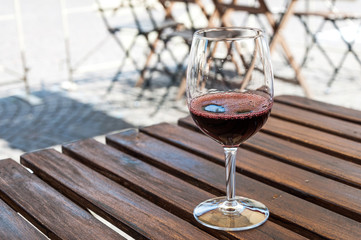 a glass of red wine on the table of street cafe,Tuscany, Italy