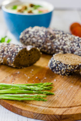 Fresh asparagus with hot bread on wooden kitchen board.