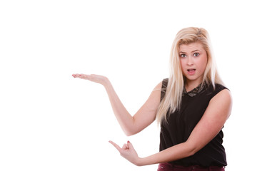 Fototapeta premium Blonde woman pointing with hands at copyspace