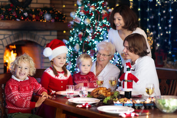 Obraz na płótnie Canvas Christmas dinner. Family with kids at Xmas tree.