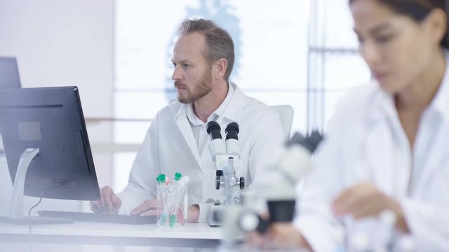  Medical research team in the lab, working on computers & analyzing samples