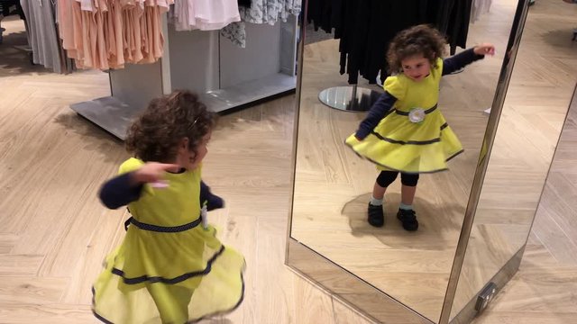 Little girl (age 03) dancing in front of a mirror. Real people. Copy space