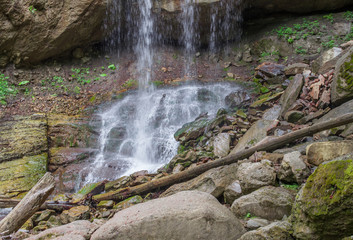 The blockage of boulders and logs at the foot of the waterfall.