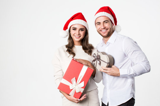 Young happy couple in Santa hat with gift boxes.